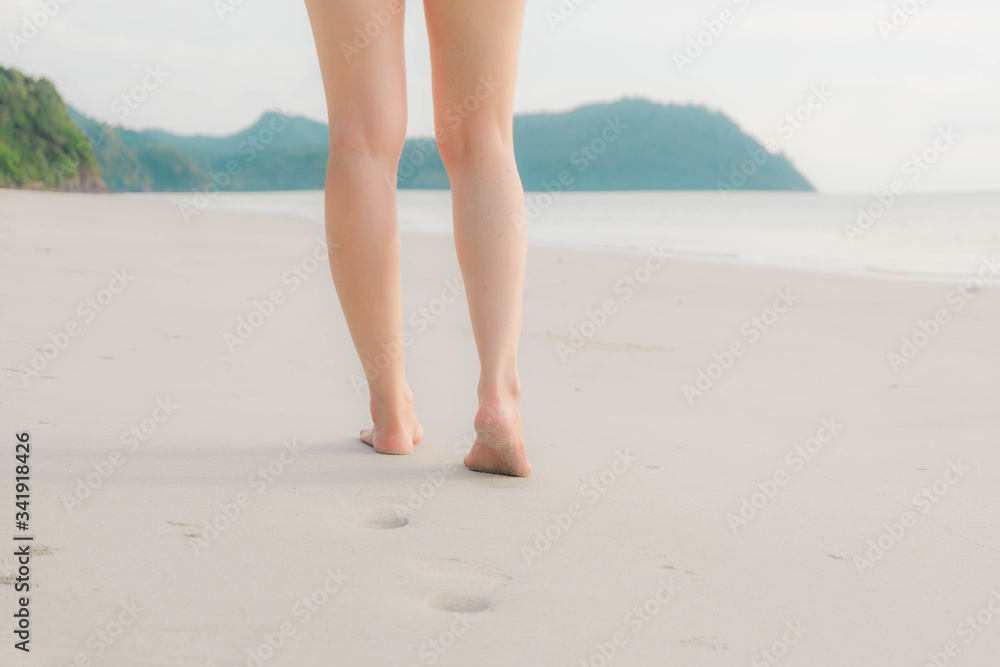 cropped of the legs and feet. Women walking on the beach, freedom and lifestyle in summer, holiday and vacation ,selective focus cropped of the legs and feet. Women walking on the beach, freedom and lifestyle in summer, holiday and vacation ,selective focus