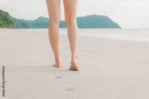 cropped of the legs and feet. Women walking on the beach, freedom and lifestyle in summer, holiday and vacation ,selective focus
