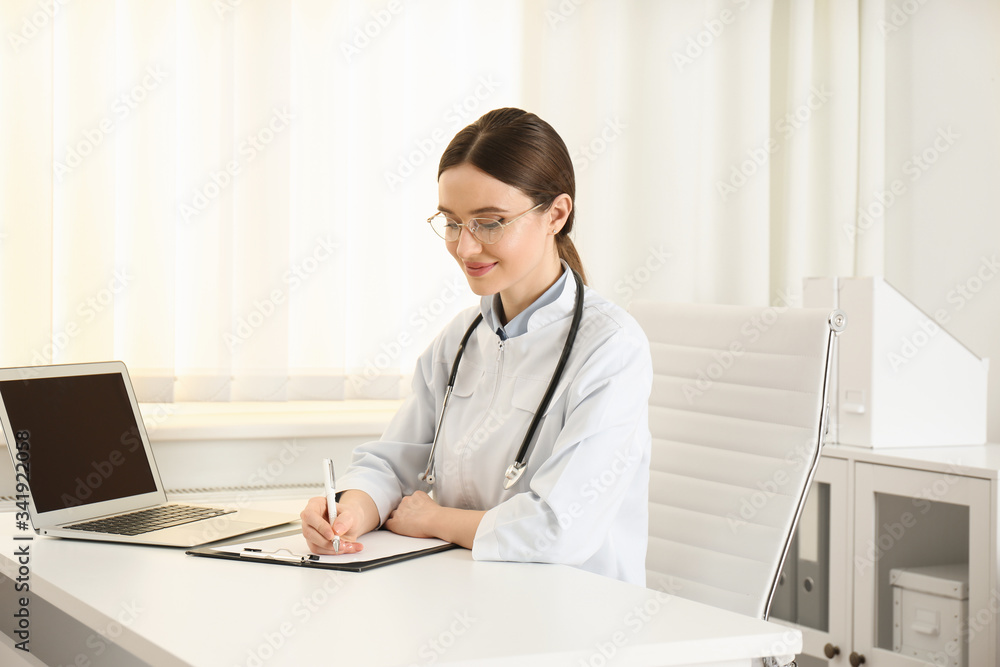 Young female doctor working at table in office Young female doctor working at table in office