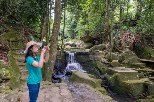 Young thai woman taking photos with beautiful nature park after quarantine home stay.