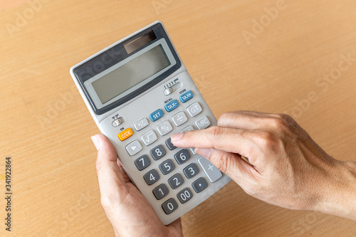 Man hands holding and using a calculator