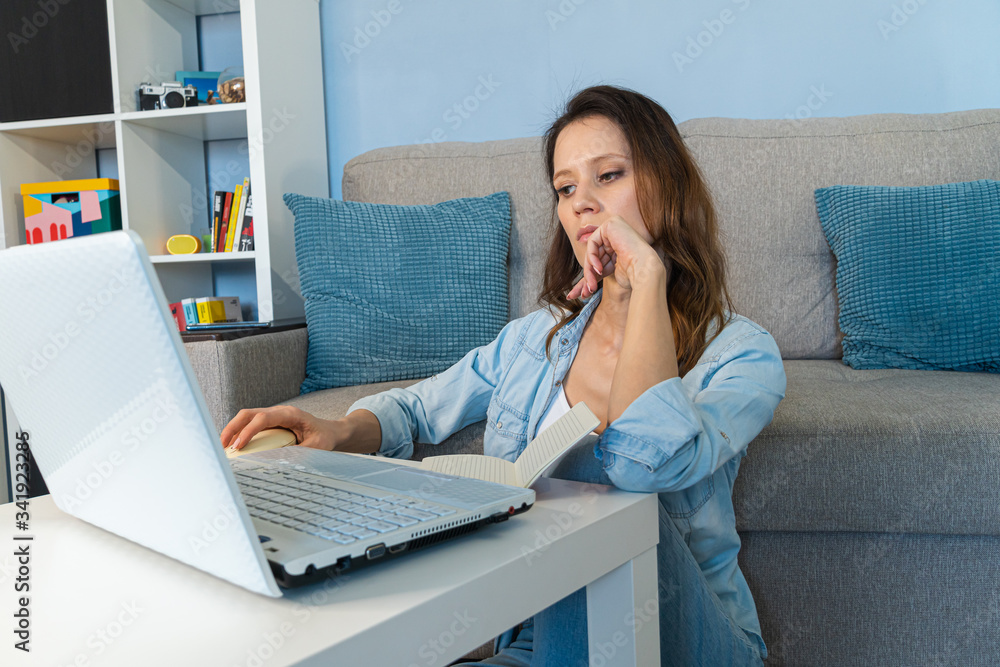Bored young woman sit at home office table look in distance unable to work at laptop Bored young woman sit at home office table look in distance unable to work at laptop