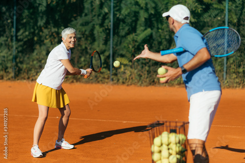 Active Senior Woman Practicing Tennis © Microgen