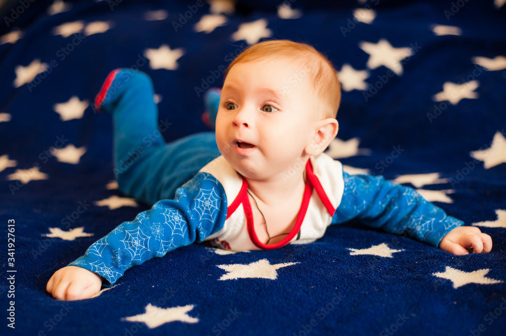 Fototapeta premium little boy lies on a blue background with stars