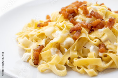 close up of fresh homemade pasta with cheese and fried bacon