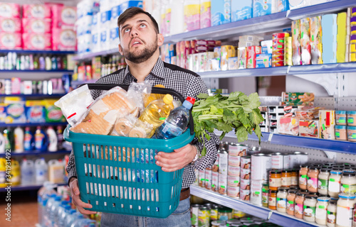 Tired man with heavy shopping basket photo