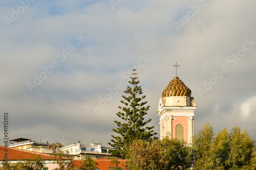 Top of the bell tower of the little church of Saint Joseph in the coastal town of Arma di Taggia against cloudy sky, province of Imperia, Riviera of Flowers, Liguria, Italy