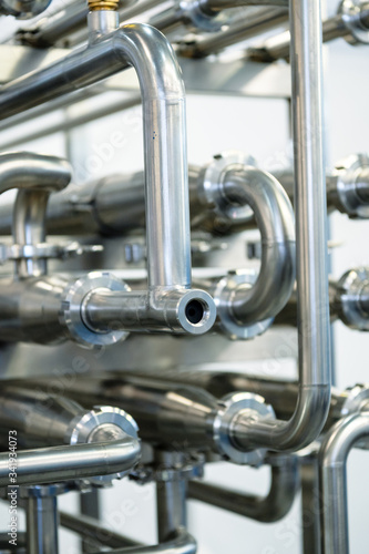 Industrial stainless steel piping connected by special nuts.