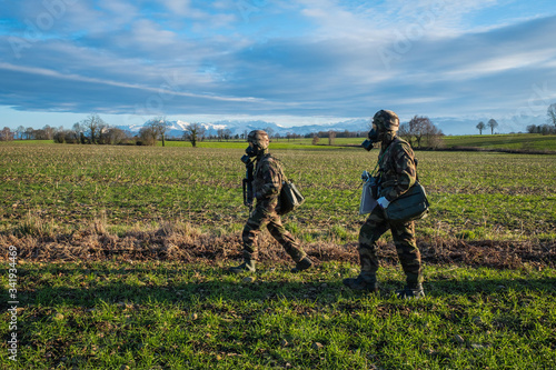 soldiers with gas masks during a simulation of conflict between soldiers and threats with fake corpses, fake threats and fake wounds during the training of French paratroopers photo