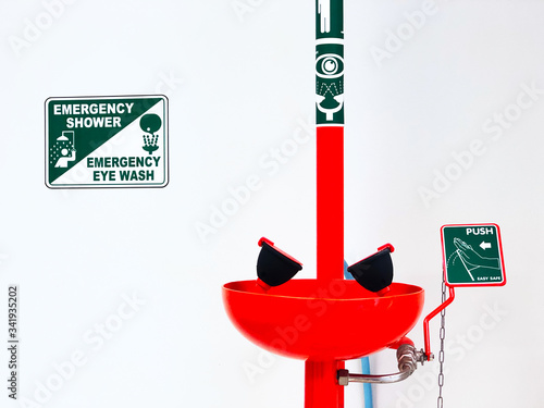 Eye wash station and push on button for flowing the water washing eyes, when touch with Acid or toxic chemical, safety first protection equipment in chemistry laboratory. Isolated in white background.