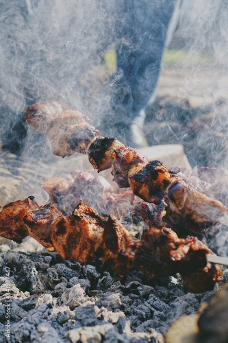 grilled meat skewers on fire in smoke