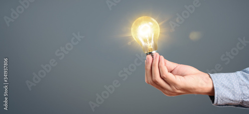 Hand of holding illuminated light bulb. innovation inspiration concept.