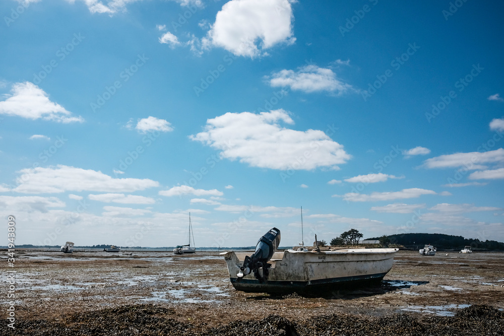 Boat standing in mud in a low tide Boat standing in mud in a low tide