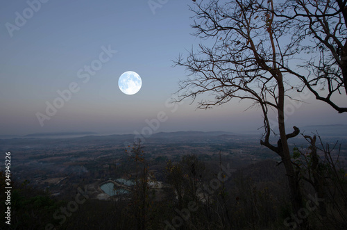 Full moon downs in early morning over mountain