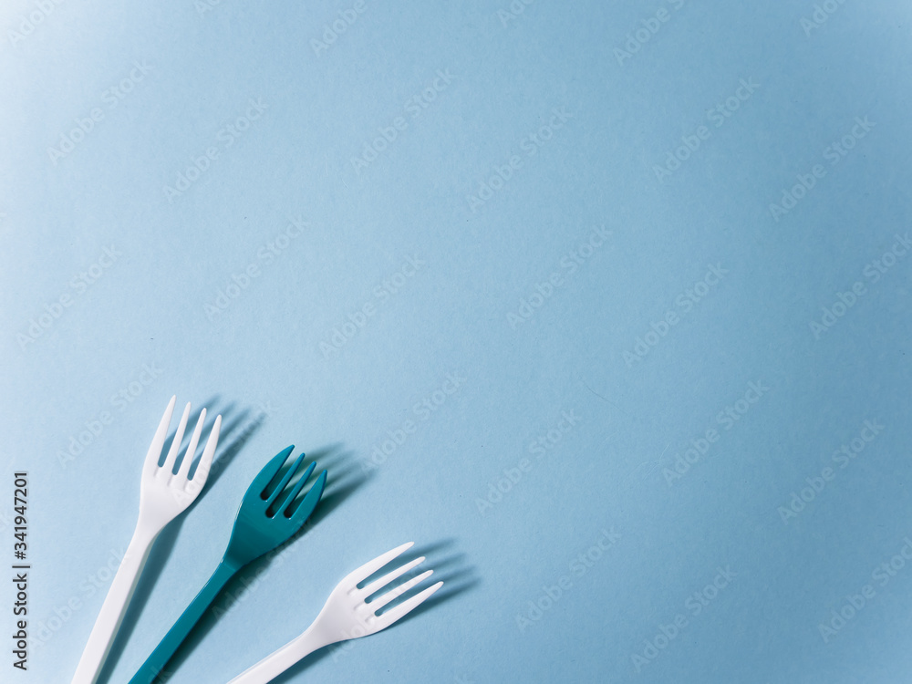 Plastic dishes, disposable tableware, plates, glasses, spoons, forks on a blue background. Caring for the environment. The problem is recycling. Reuse, safe planet, environmental concept. Trash. Plastic dishes, disposable tableware, plates, glasses, spoons, forks on a blue background. Caring for the environment. The problem is recycling. Reuse, safe planet, environmental concept. Trash.