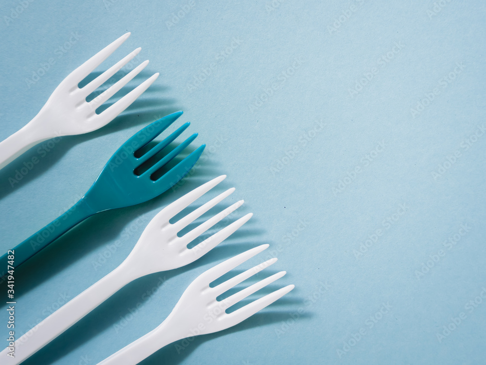 Plastic dishes, disposable tableware, plates, glasses, spoons, forks on a blue background. Caring for the environment. The problem is recycling. Reuse, safe planet, environmental concept. Trash. Plastic dishes, disposable tableware, plates, glasses, spoons, forks on a blue background. Caring for the environment. The problem is recycling. Reuse, safe planet, environmental concept. Trash.