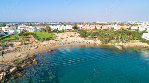 Aerial bird's eye view of Sirena beach in Protaras, Paralimni, Famagusta, Cyprus. The famous Sirina bay tourist attraction with sunbeds, golden sand, restaurant, people swimming in the sea from above.