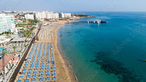 Aerial bird's eye view of Sunrise beach Fig tree, Protaras, Paralimni, Famagusta, Cyprus.The famous tourist attraction family bay with golden sand, boats, sunbeds, restaurants, water sports from above