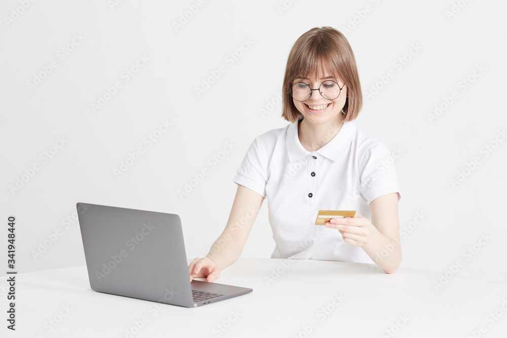 Pretty blonde pays for purchases online on a laptop, in an online store, sitting at home. Payment is made by credit card Pretty blonde pays for purchases online on a laptop, in an online store, sitting at home. Payment is made by credit card