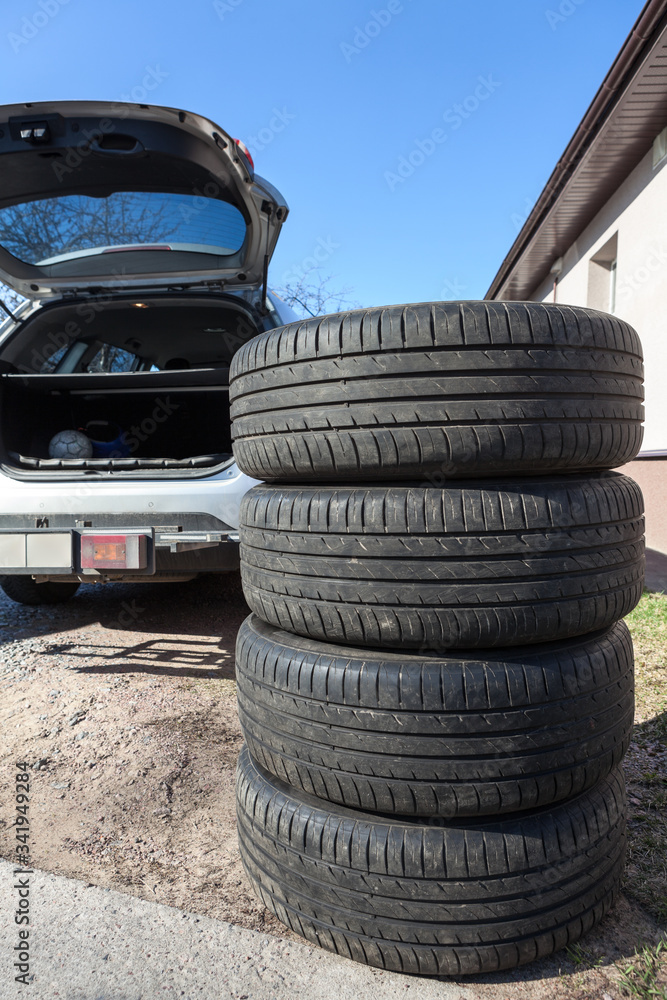 Obraz premium Four big wheels with summer tire are ready for loading inside the trunk of a passenger car