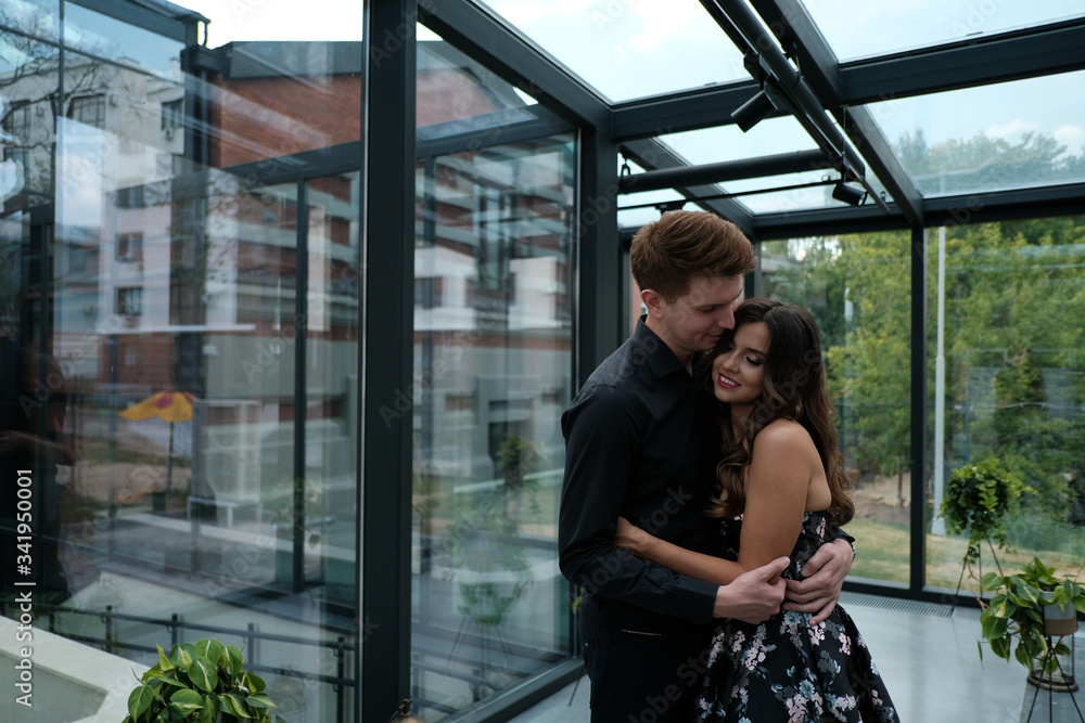 beautiful couple-a girl in a magnificent dress and a guy in a black shirt and trousers are in a building with a beautiful interior beautiful couple-a girl in a magnificent dress and a guy in a black shirt and trousers are in a building with a beautiful interior