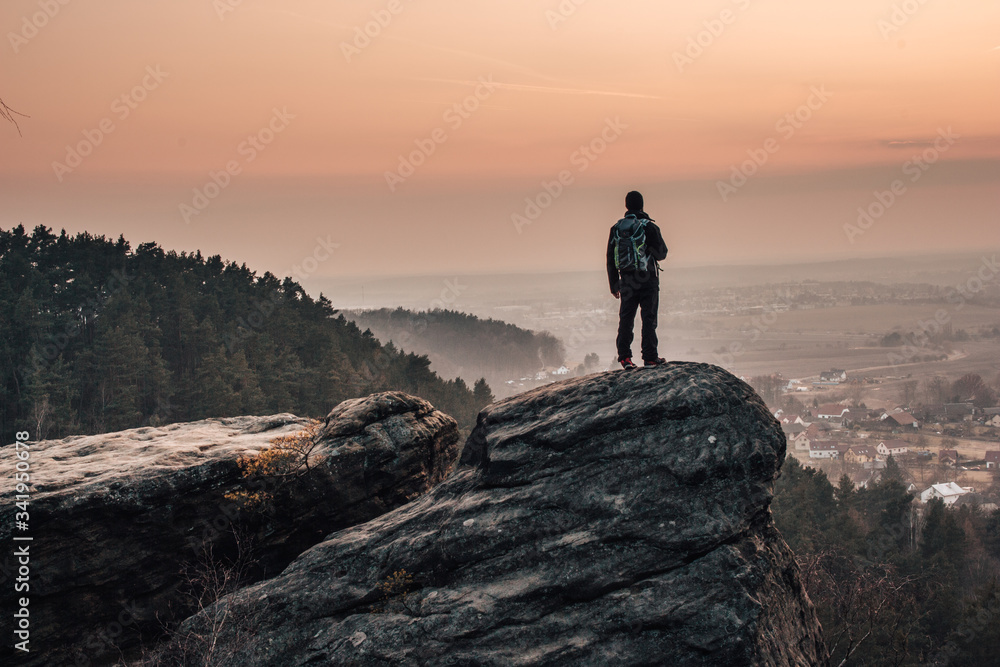 A man looking into the landscape from the top of the rock in Bohemian Paradise (Český ráj). 