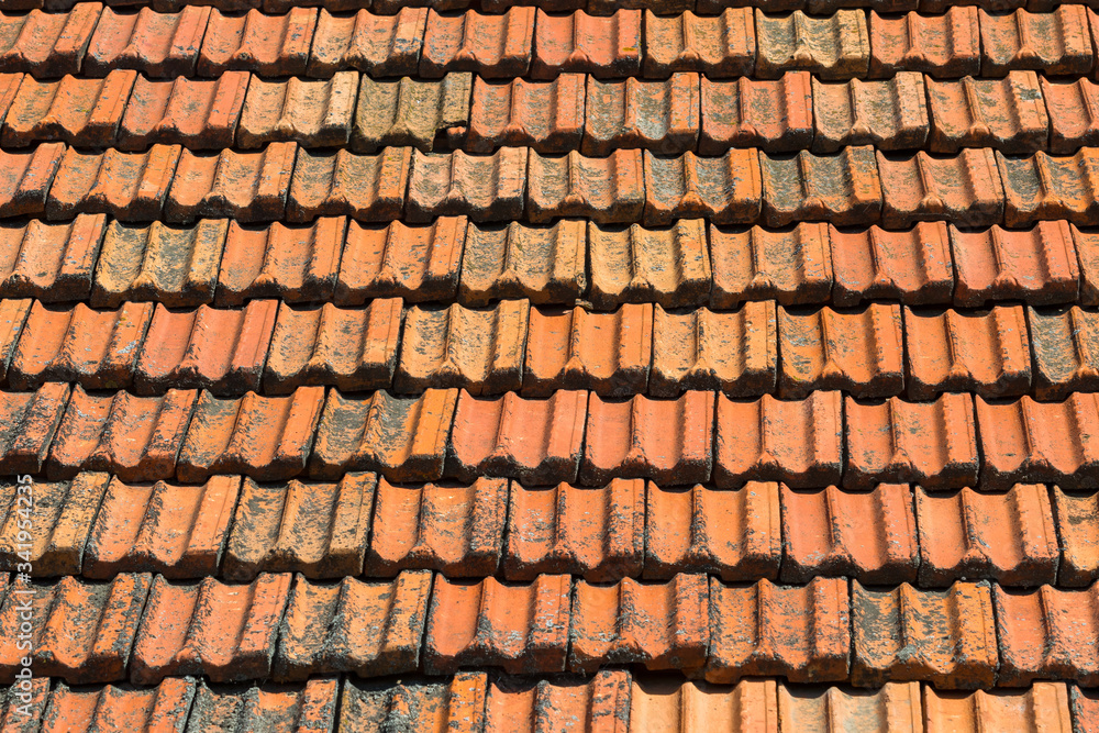 Texture of orange clay roof tiles. Red old dirty roof. Old roof tiles. Construction equipment build a house.