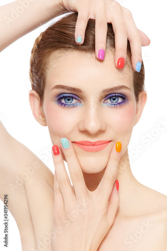 Young beautiful smiling girl with fancy bright makeup and colorful nail polish