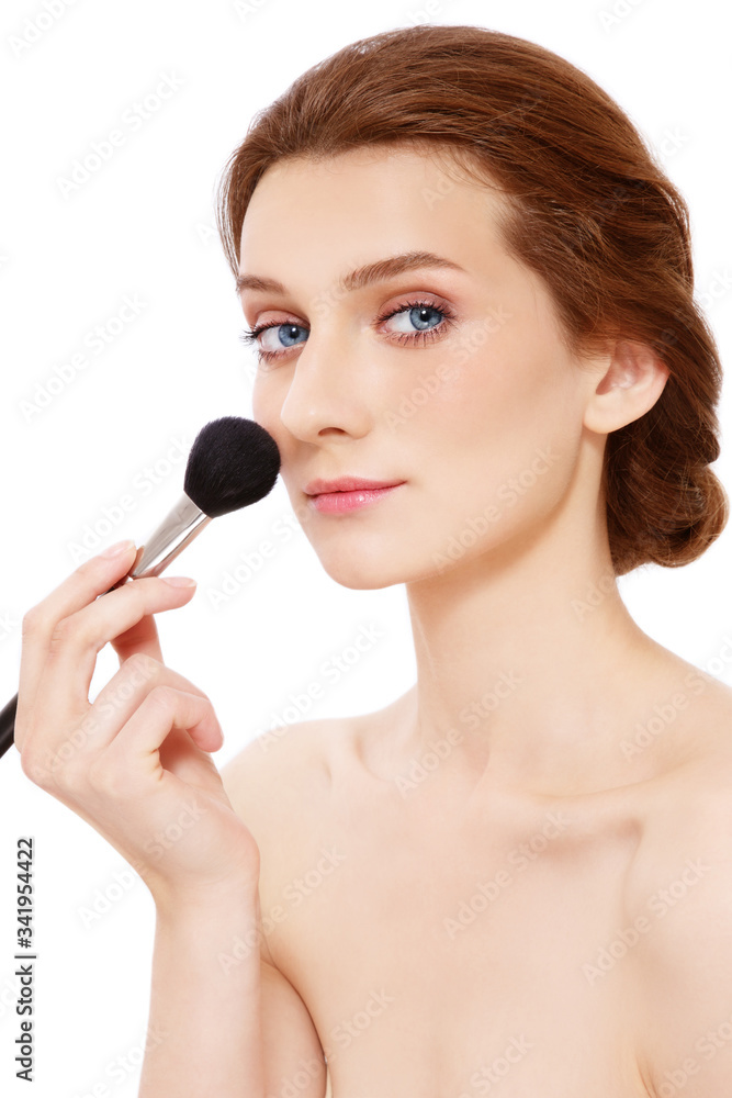 Young beautiful woman applying powder with makeup brush Young beautiful woman applying powder with makeup brush