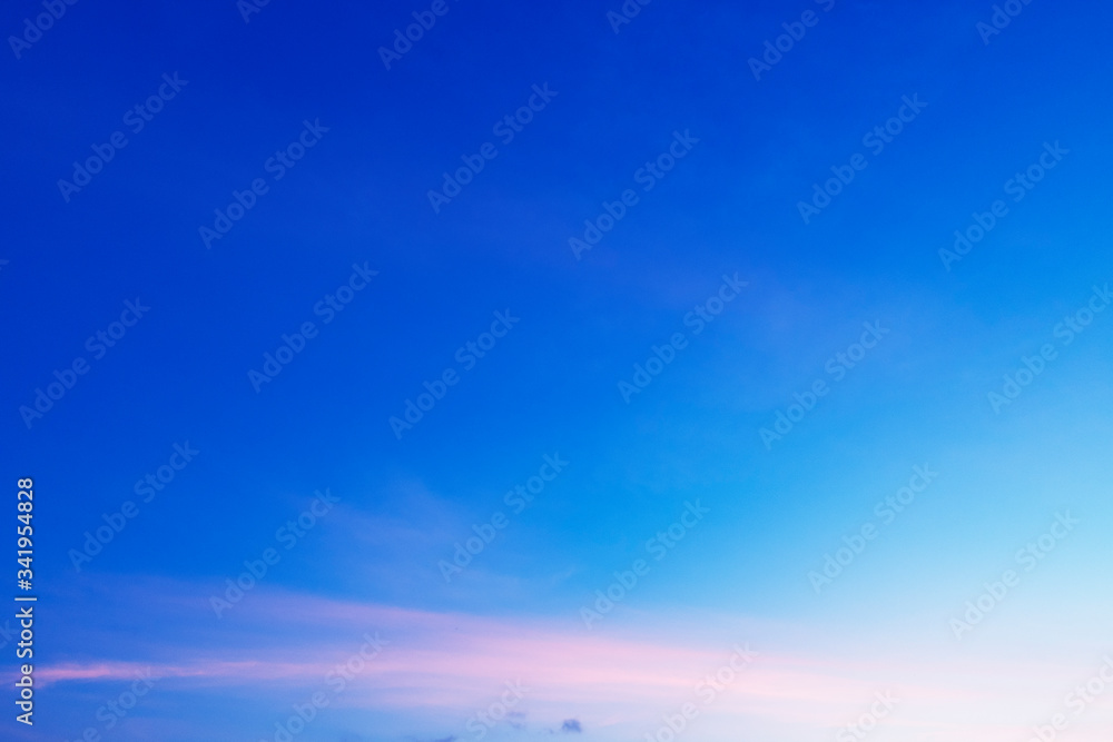 Fototapeta premium Colorful sunny blue sky with gradient pink, purple, orange color with white fluffy cloud on bright sunny horizon at twilight sunset or morning sunrise in tropical summer or spring sunlight & sun ray 