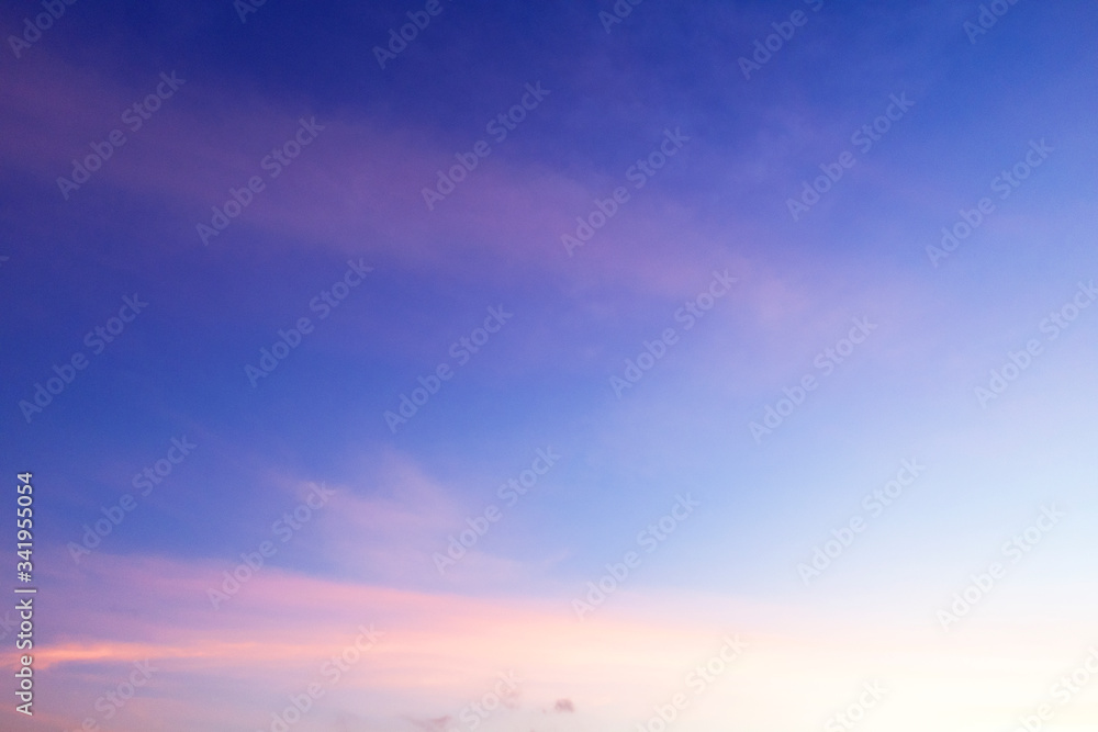 Colorful sunny blue sky with gradient pink, purple, orange color with white fluffy cloud on bright sunny horizon at twilight sunset or morning sunrise in tropical summer or spring sunlight & sun ray  