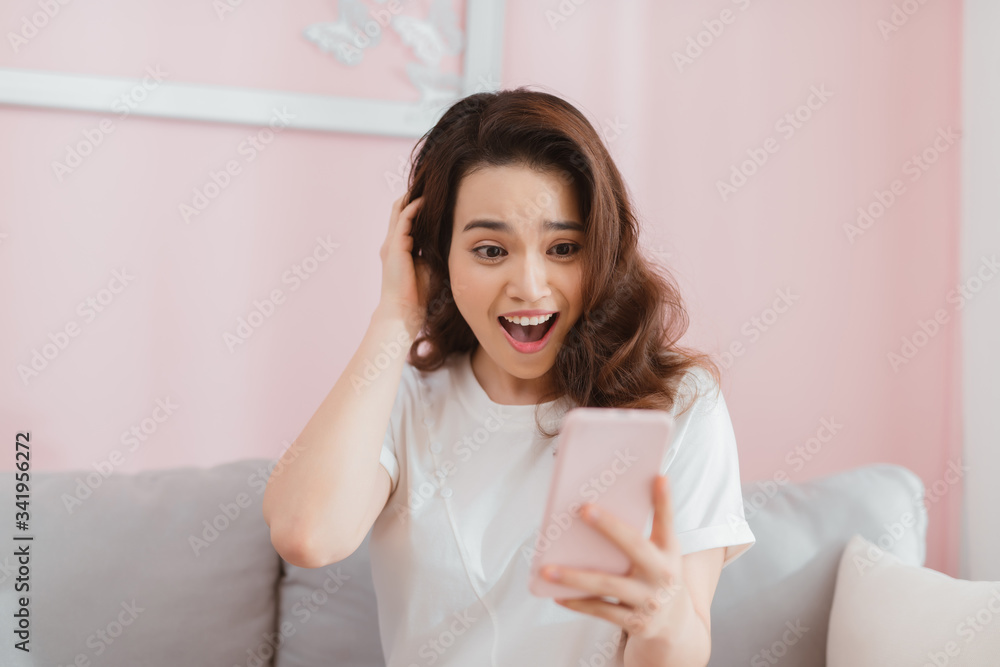 Young asian woman looking at surprised mobile with surprise expression showing emotion looking at message Young asian woman looking at surprised mobile with surprise expression showing emotion looking at message