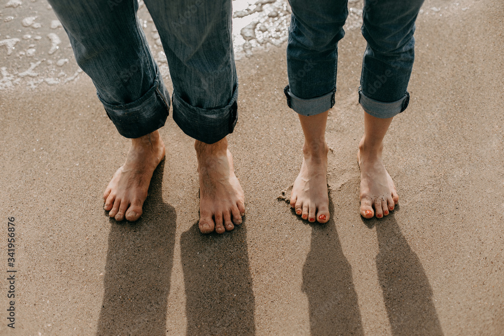 Bare feet of lovers on the seashore. Close-up on top Bare feet of lovers on the seashore. Close-up on top