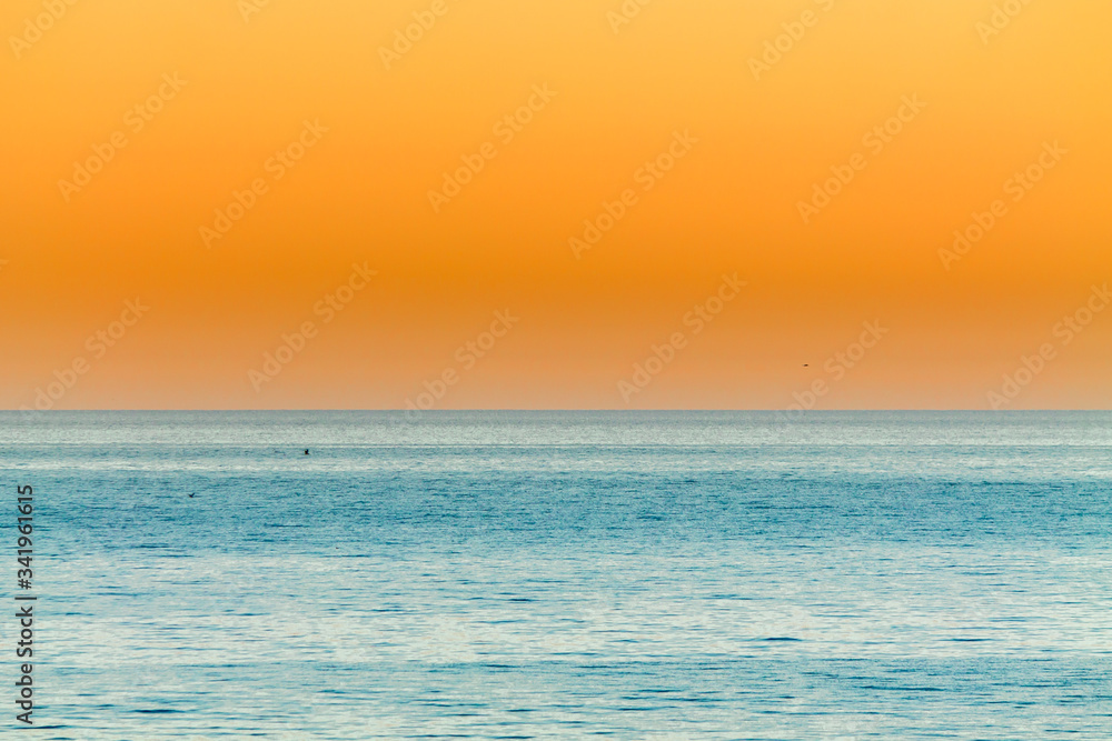 orange Sunset over the calm blue ocean orange Sunset over the calm blue ocean