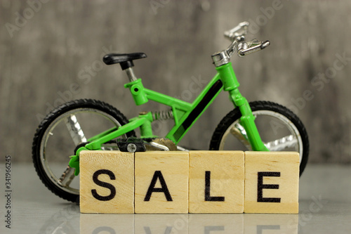 Fotografie Toy model green full-suspension mountain bike on a gray background and the word