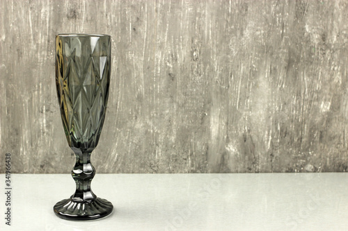 Dark champagne glass on a grey background