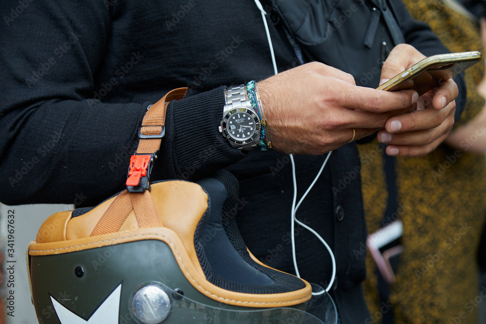 Man with Rolex Submariner watch and helmet looking at smartphone on  September 19, 2019 in Milan, Italy Stock Photo | Adobe Stock