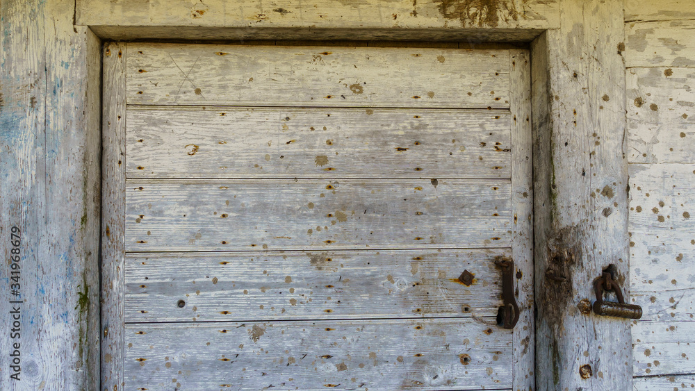 Rustic barn white door. Wooden planks and locks closeup. Peeling paint and weathered. Space for text. Texture and background. Rustic barn white door. Wooden planks and locks closeup. Peeling paint and weathered. Space for text. Texture and background.