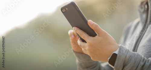 Asian woman using smartphone outdoors in the morning