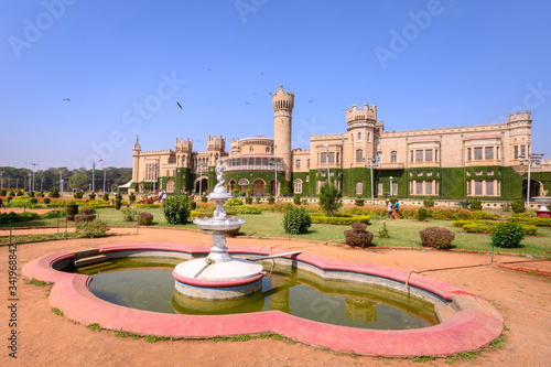 Beautiful exterior view of Bangalore Palace with a garden in front.