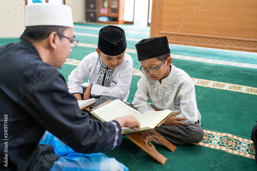 Canvas Print kid learning to read quran with muslim teacher or ustad