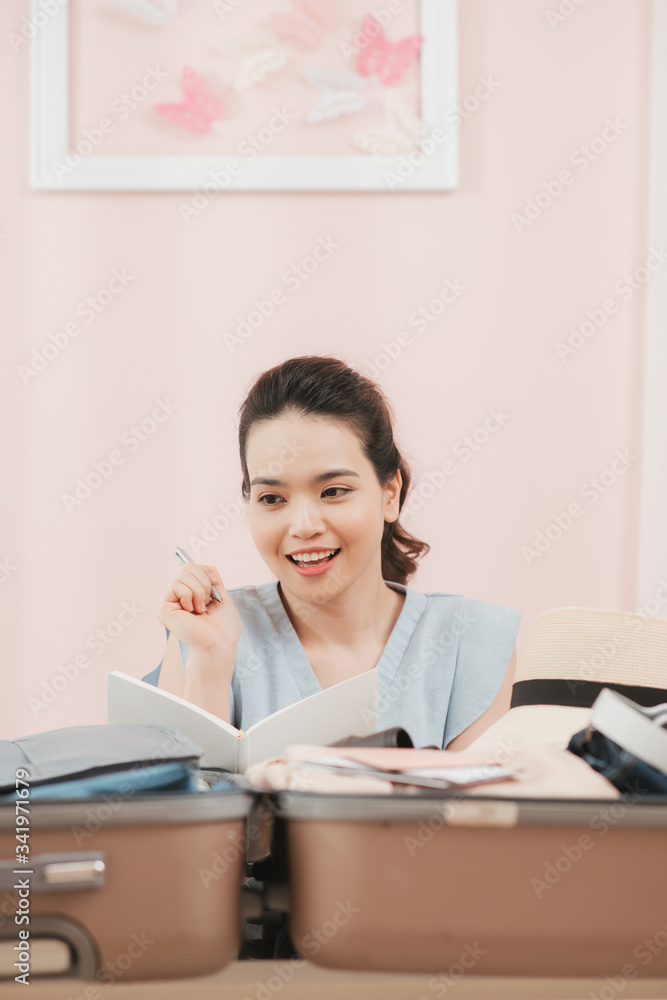 Preparing suitcase for summer vacation trip. Young woman checking accessories and stuff in luggage at home before travel. Preparing suitcase for summer vacation trip. Young woman checking accessories and stuff in luggage at home before travel.