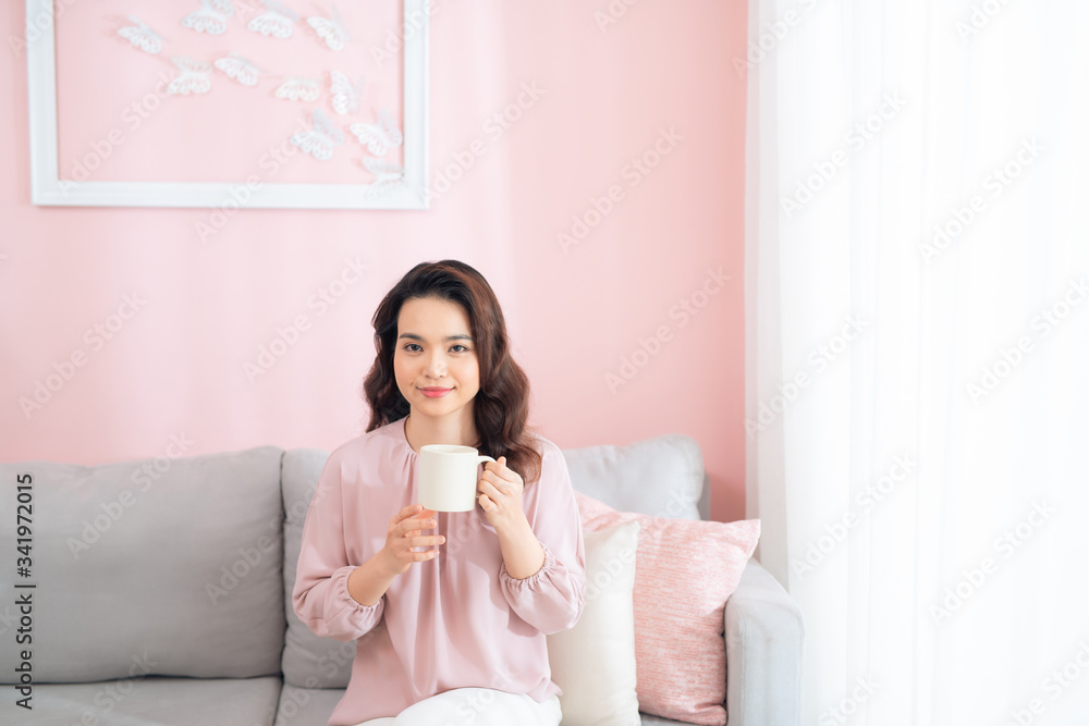 Beautiful young asian woman drinking coffee and relaxing on sofa. Beautiful young asian woman drinking coffee and relaxing on sofa.