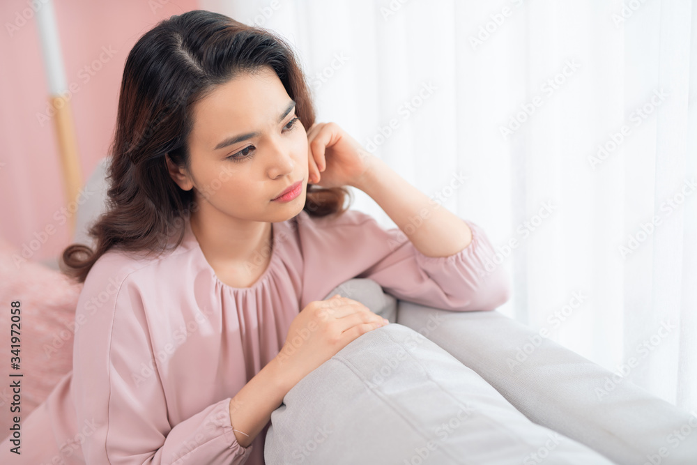 Young Asian woman sitting on couch and relaxing. Young Asian woman sitting on couch and relaxing.