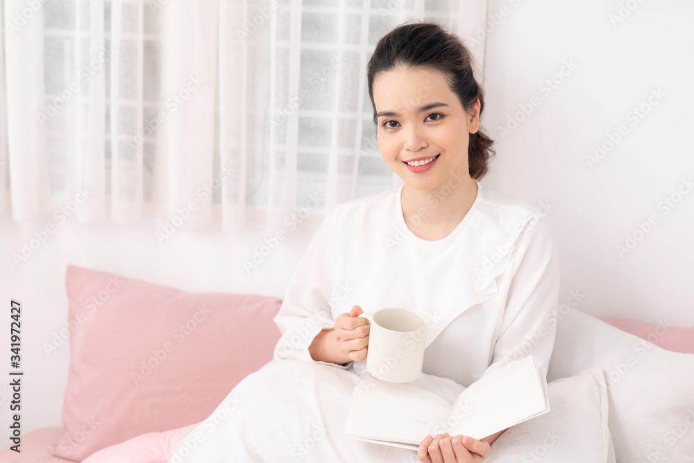 Beautiful woman reading a book on the bed in the morning Beautiful woman reading a book on the bed in the morning