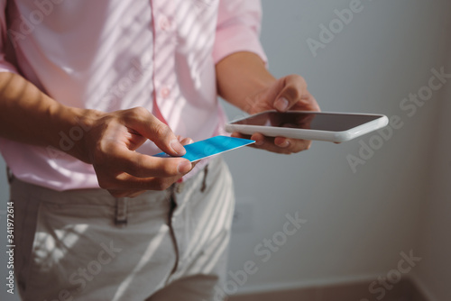 Man holding mobile phone with Payment Detail page display and credit card  online shopping concepts