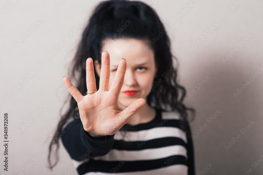 A woman shows a hand, hello. Gray background A woman shows a hand, hello. Gray background