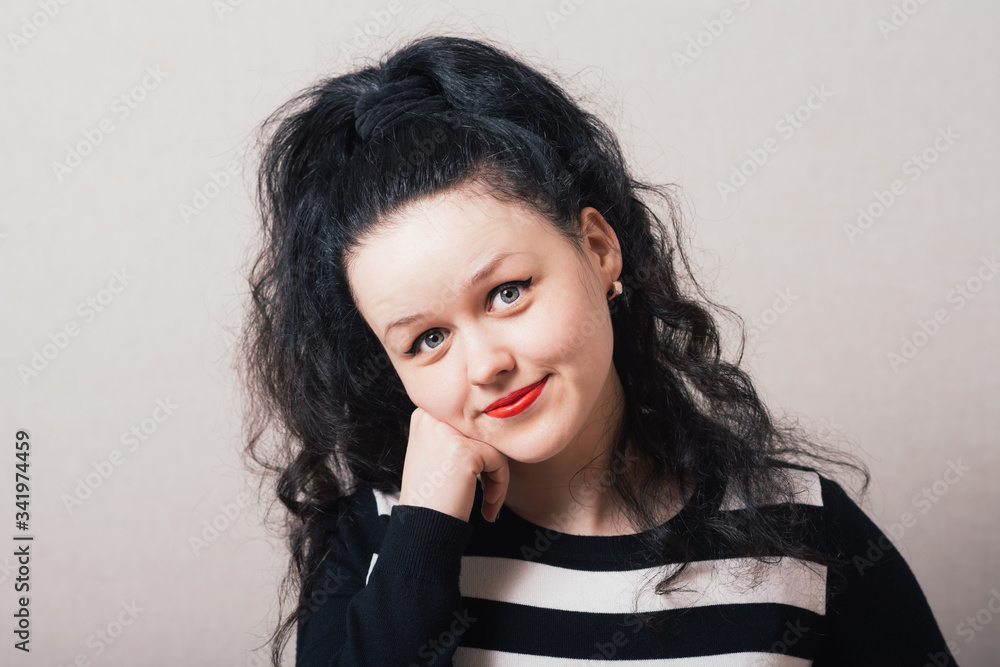Woman smiling with her head resting on his hand, fist. Gray background Woman smiling with her head resting on his hand, fist. Gray background