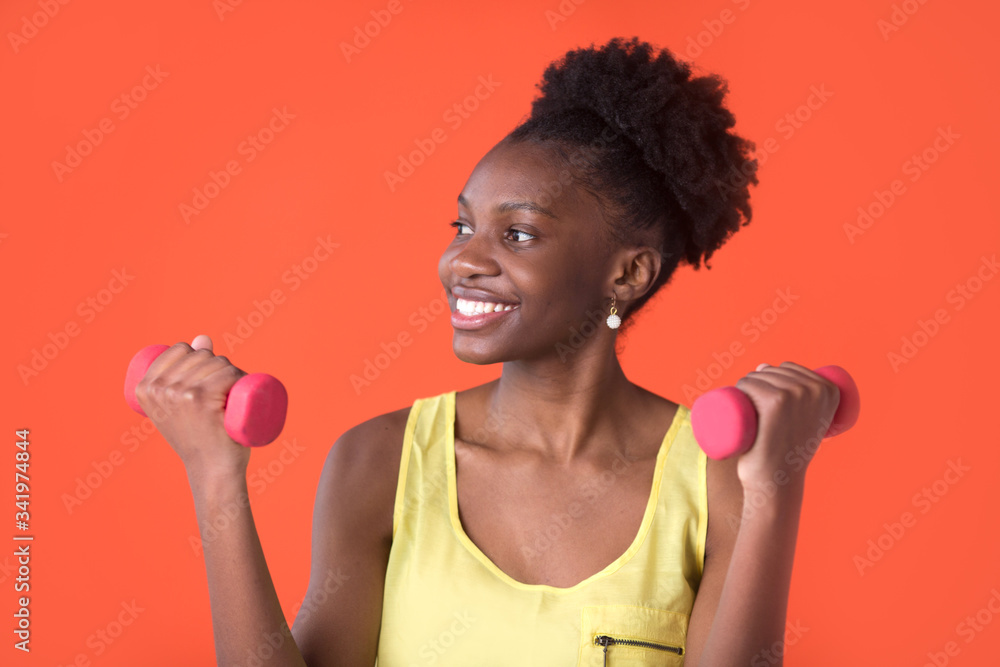 beautiful young african woman on a red background in a yellow t-shirt with dumbbells
beautiful young african woman on a red background in a yellow t-shirt with dumbbells