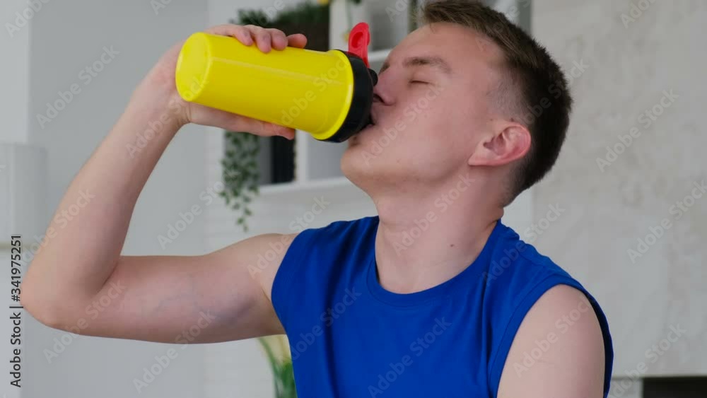 Athlete drinks protein or other sports supplement after training at home Athlete drinks protein or other sports supplement after training at home